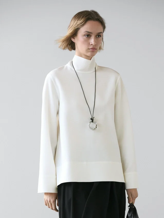 Camicetta a collo alto con dettaglio sull’orlo Camicetta a collo alto con dettaglio sull’orlo