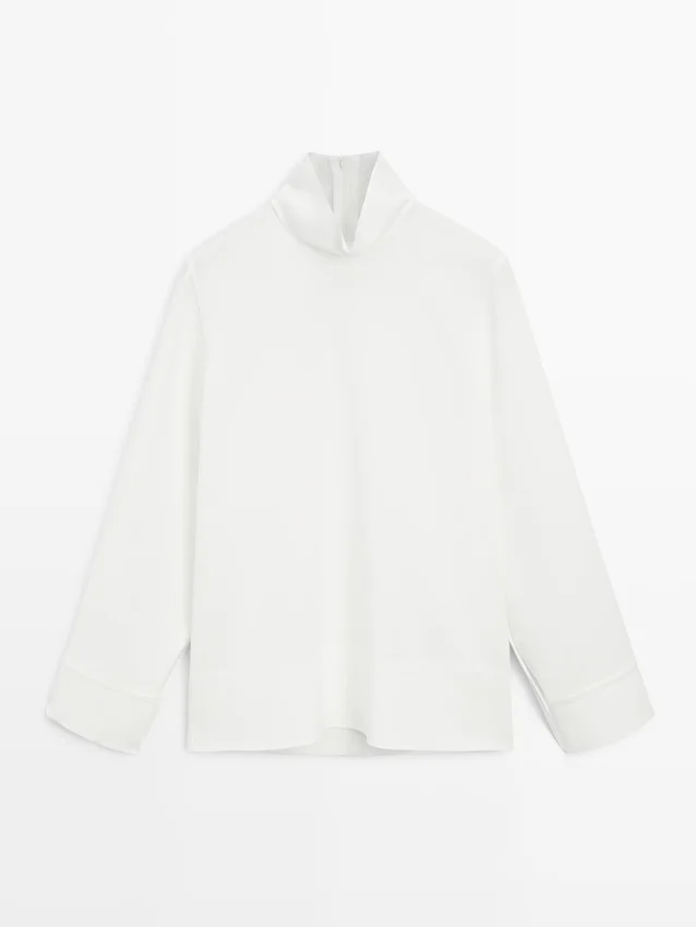 Camicetta a collo alto con dettaglio sull’orlo Camicetta a collo alto con dettaglio sull’orlo