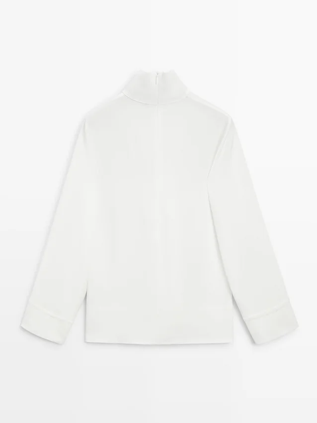 Camicetta a collo alto con dettaglio sull’orlo Camicetta a collo alto con dettaglio sull’orlo