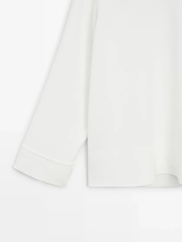 Camicetta a collo alto con dettaglio sull’orlo Camicetta a collo alto con dettaglio sull’orlo