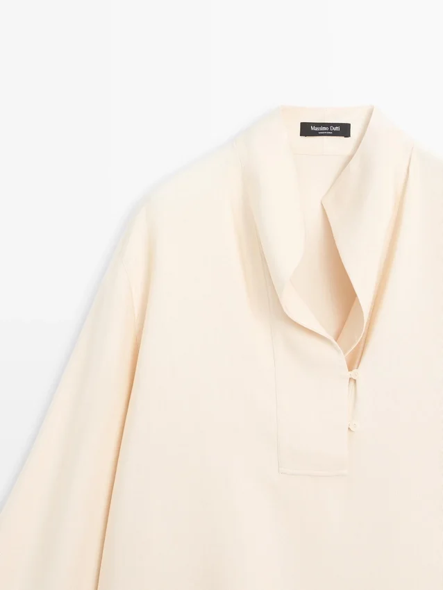 Camicetta fluida con dettaglio a pettorina Camicetta fluida con dettaglio a pettorina