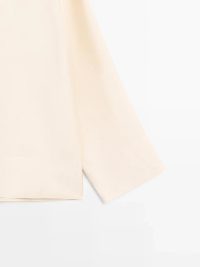 Camicetta fluida con dettaglio a pettorina Camicetta fluida con dettaglio a pettorina